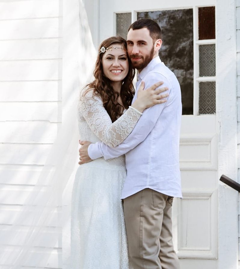 A handsome man hugs his beautiful new wife