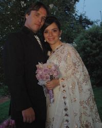 An American Christian man looks pleased to be standing next to his beautiful Colombian wife