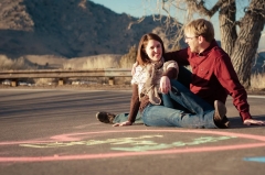 A calm and relaxed couple sit in a parking lot entertwined
