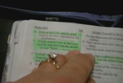 A engagement ring is in focus with The Bible in the background
