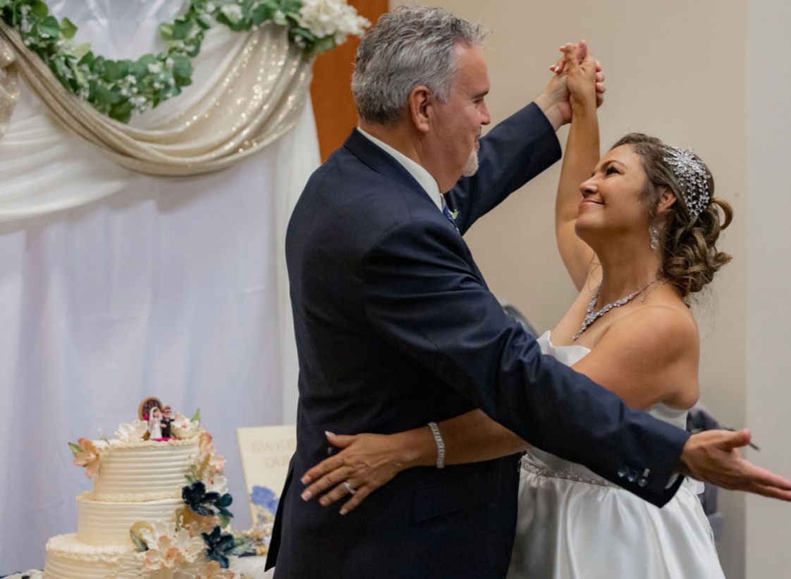 A bride gazes into her new husband's eyes as they dance