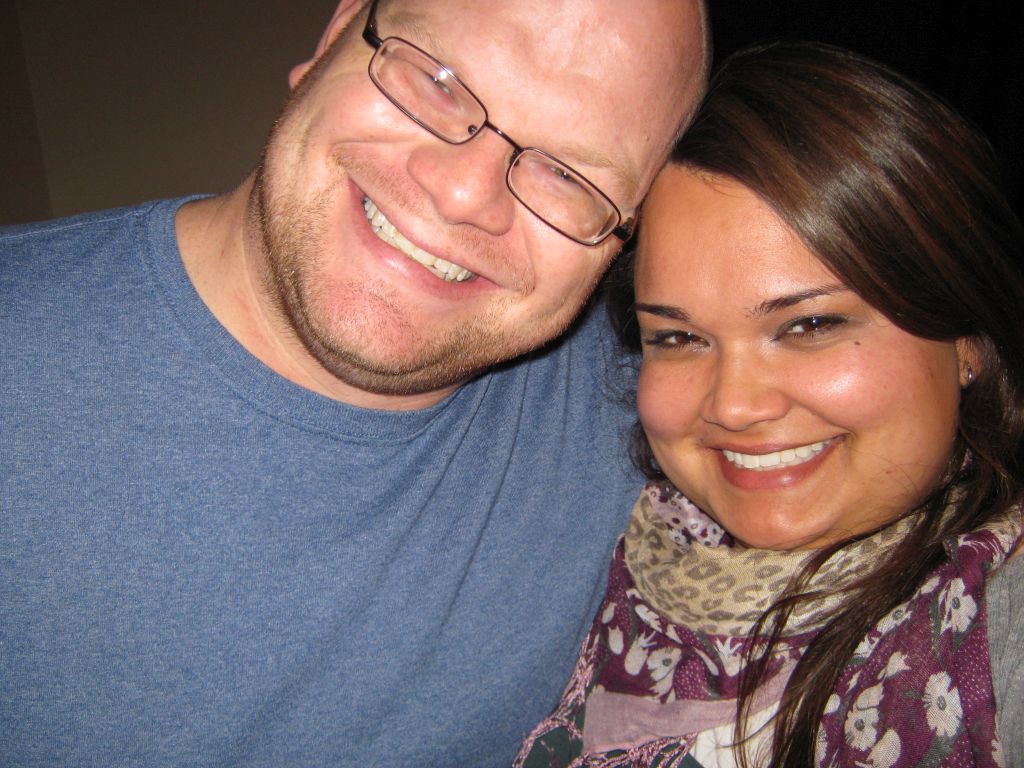 A Christian single man with glasses and a big smile leans in for a selfie with a beautiful woman who has a gorgeous smile