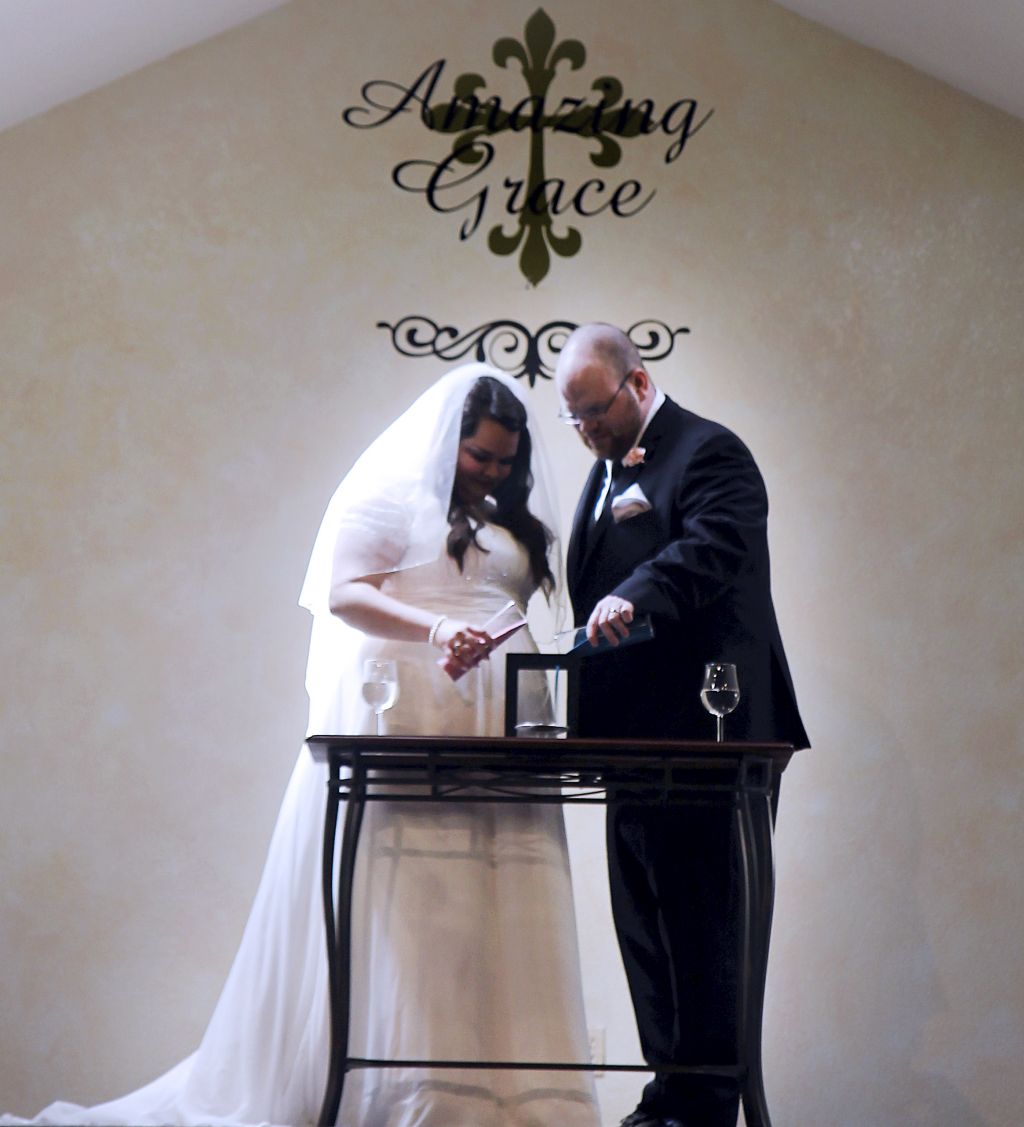 A bride and groom light the unity candle during their wedding ceremony at church