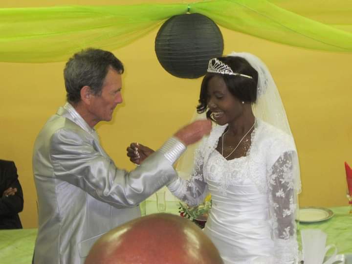A beautiful Black Christian bride is fed wedding cake by her new husband