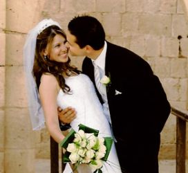Canadian Christian leans in to kiss his Mediterranean bride who smiles broadly