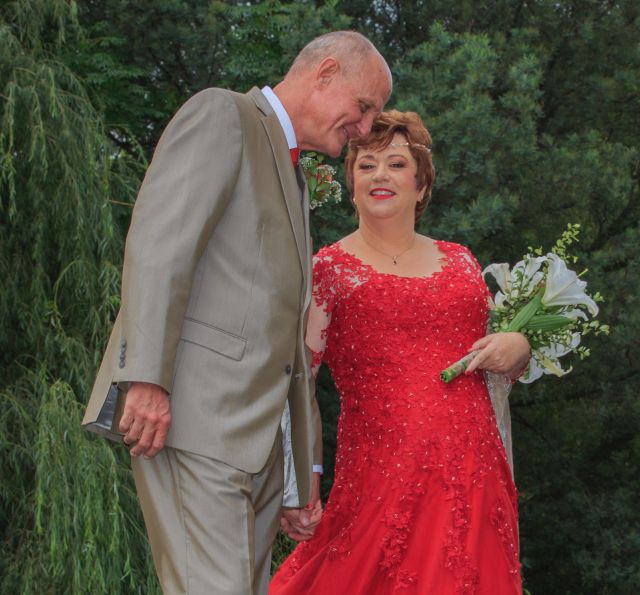 Senior Christians now married stand together holding hands in forest