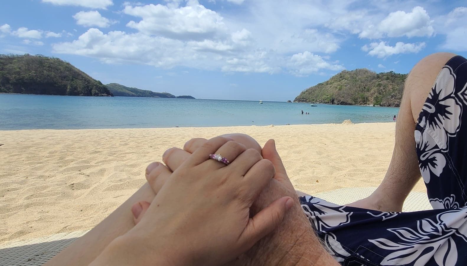 Newly engaged Christians hold hands on a beautiful beach
