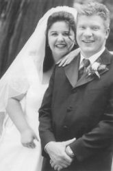 An overjoyed Christian woman lays her arm affectionately on her pleased groom