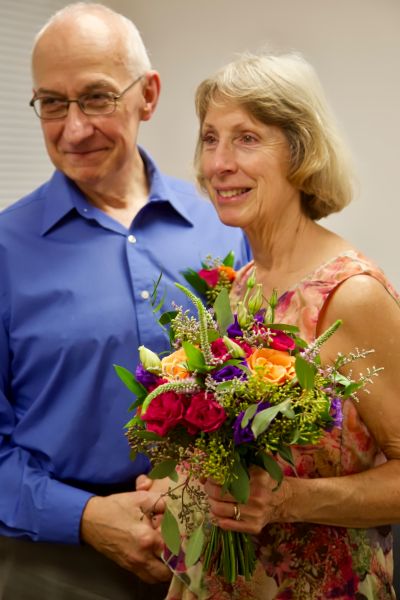 Very please senior Christian couple posing with wedding flowers