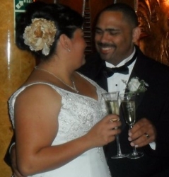 A groom smiles and toasts his new wife while holding her on her wedding day