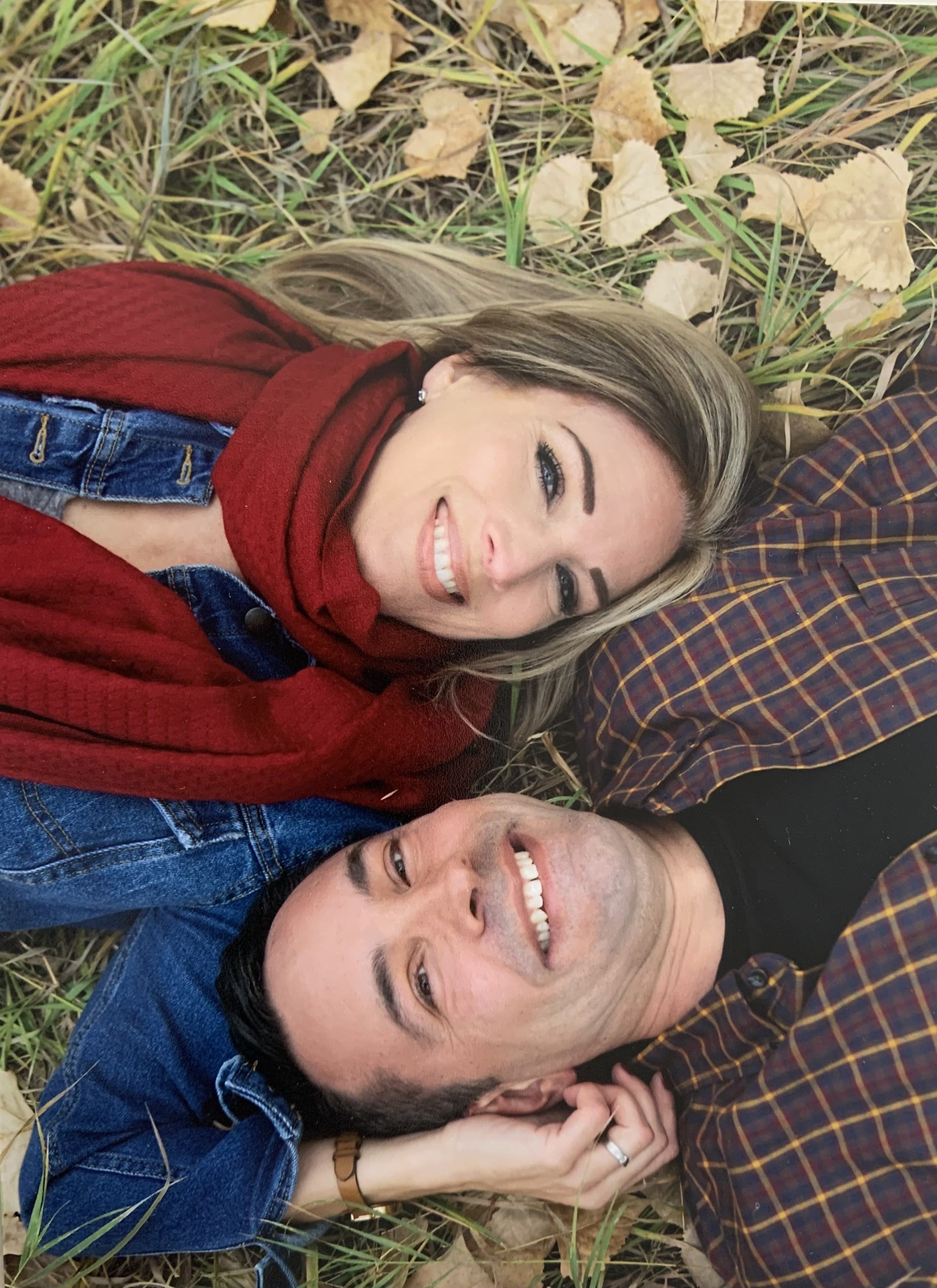 A couple laugh together while lying upside down in the Autumn
