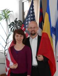 Former Christian singles from two different continents wrap themselves in their country flags while hugging