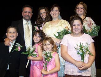 Blended family for Christian couple from Indiana, all holding flowers and smiling