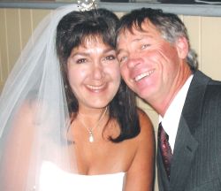 A very joyful looking Christian couple laugh together cheek to cheek just after marrying