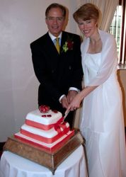 Newlyweds pose before cutting a wedding cake