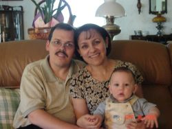 A happily married Christian woman sits with her new baby and her husband