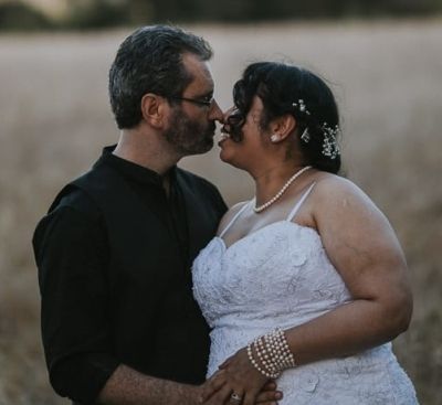 Man holding his Christian bride who is leaning in to kiss him