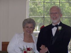 Former Senior Christian single stands next to his new smiling bride