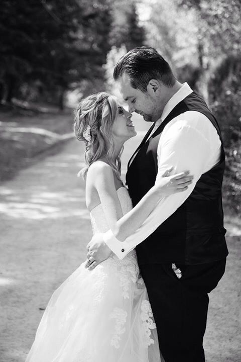 Gorgeous newlywed Christians embrace on tree-lined street
