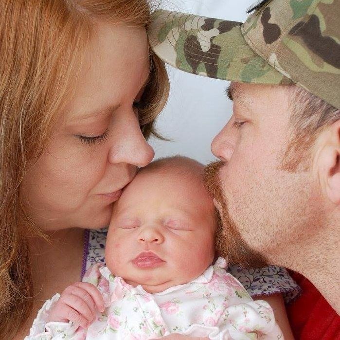 New Christian parents kiss their newborn daughter