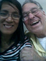 A White man laughs heartily with his Asian wife as they take a picture