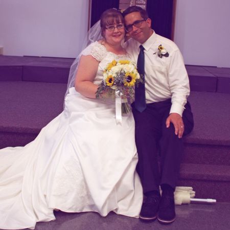 Sweet looking Christian couple seated and smiling after marrying
