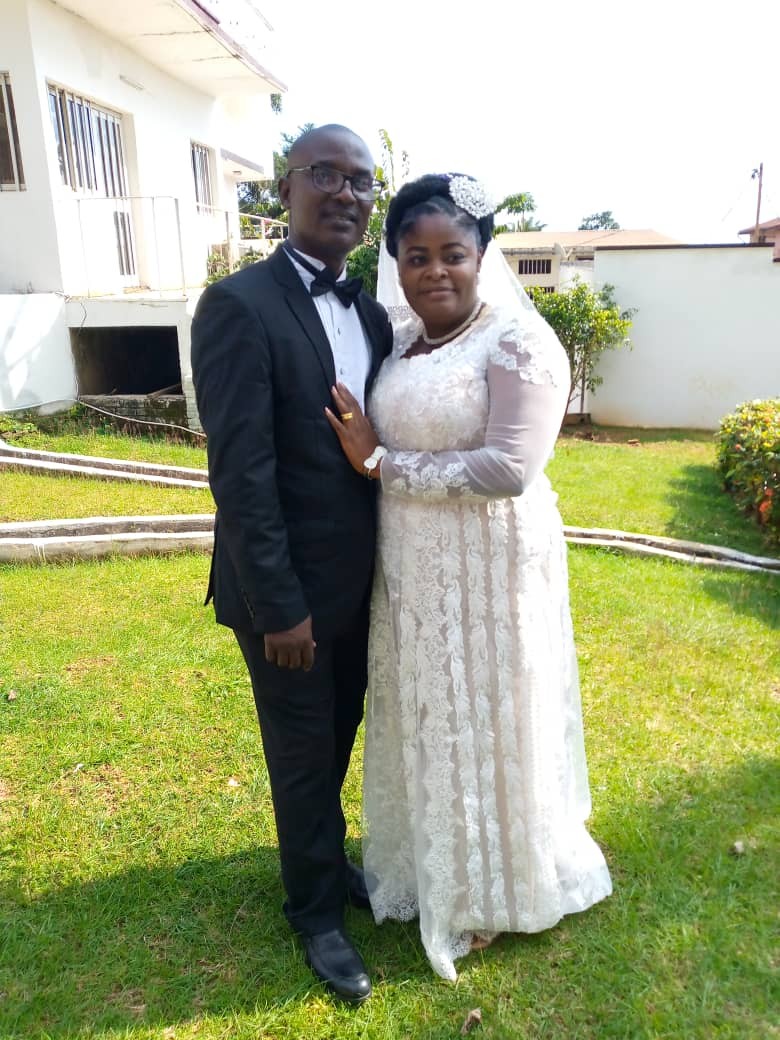 African Christian couple standing on grass and smiling