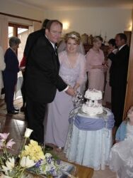 Christian couple smiles as they cut their wedding cake