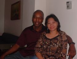 An interracial Christian couple site arm in arm on the couch