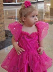 A cute girl in a pink dress in the mall