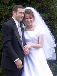 Excited Christian couple hold hands and lean in close together after marrying