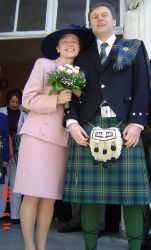 Romanian Christian marries a man in a kilt as they pose outside together full of smiles