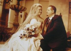 Newlywed Christians stare intently at each while seated hand in hand