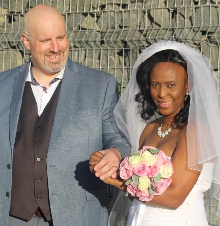 Groom only has eyes for his beautiful bride who glows in white wedding dress and bouquet
