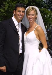 Attractive Christian couple from NY smile together at their outdoor wedding