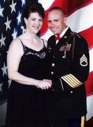 Christian army man holds hands with a beautiful woman in front of large American flag
