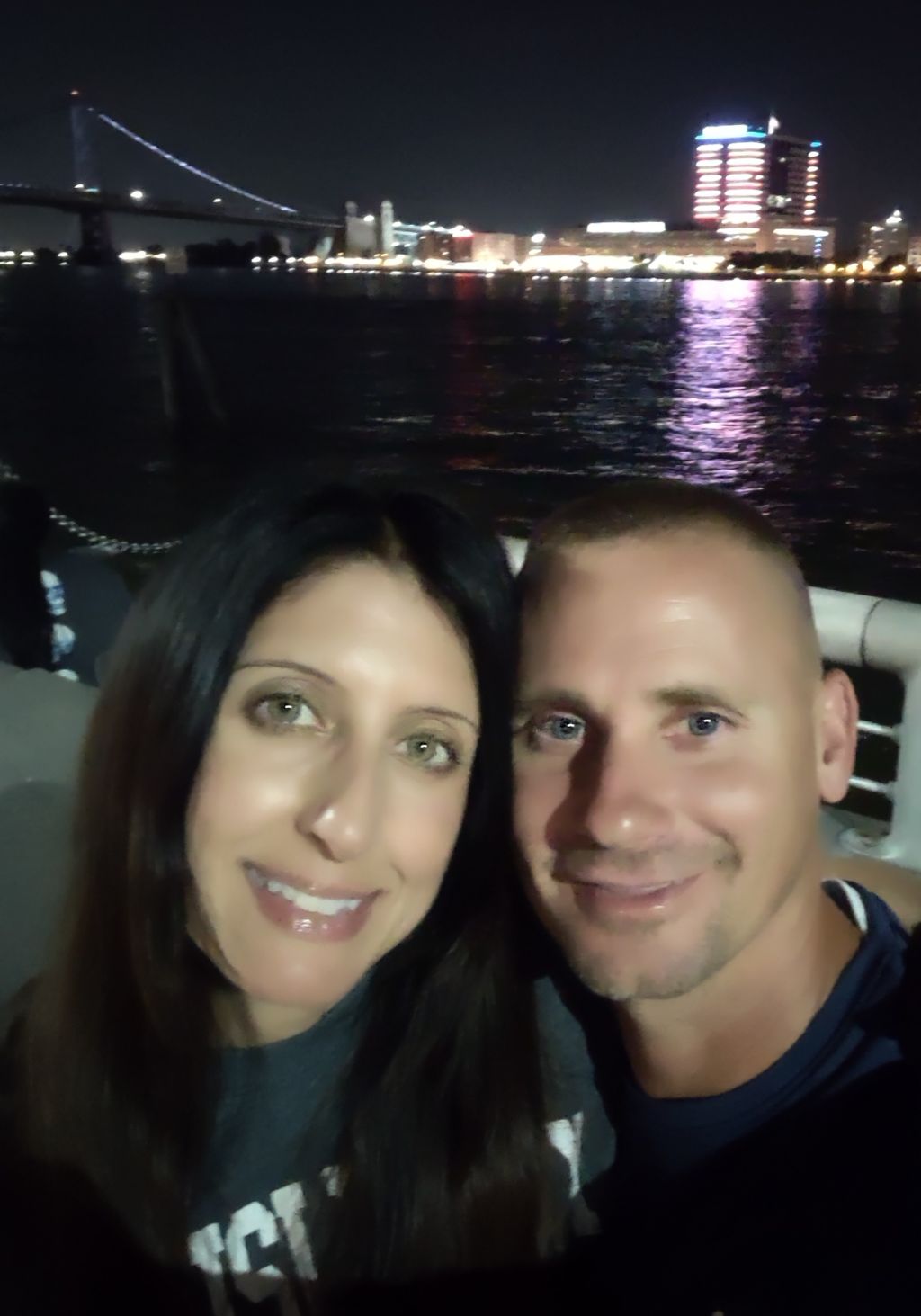 Christian singles laugh together on a river boat cruise at night