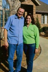 A laughing man wraps his arm around a Texas Christian woman who smiles