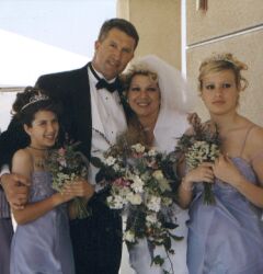 A man hugs his daughter and new wife as blended family are united
