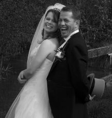 Man tries to hide his tophat but fails to do so while laughing next to a pretty woman