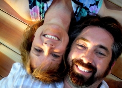 A couple lie upside down smiling
