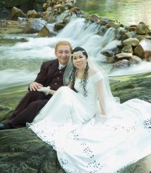 Beautiful shot of Australian and Malaysian Christians sitting by rapids after marrying