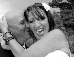 A woman screams with joy and laughter as her husband tries to kiss her