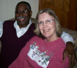 Midwest Christian senior couple sitting together and smiling on the couch