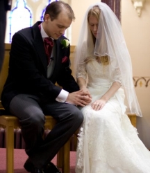 A couple pray together on their wedding day, hand in hand