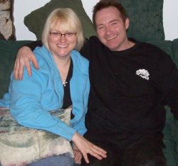 A couple look very happy together and laughing with arms around each other