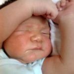 Sleeping baby tries to cover his eyes