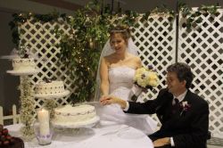 Michael and Katrina laugh while cutting the wedding cake