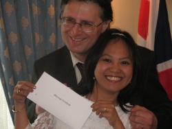 A jubilant interracial couple shows off proof of marriage