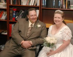 A seated couple look very relaxed and pleased on their wedding day